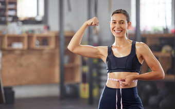 苗条的适合减肥法女人持有测量磁带腰弯曲肌肉庆祝失去重量实现目标微笑女运动员快乐饮食锻炼
