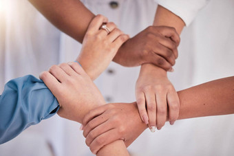 多样化的的同事们手持有手腕支持团结忠诚团队合作工作场所专业业务协同作用信任协作工作策略目标