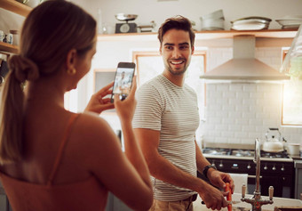 女人采取照片电话的男朋友厨房成键笑烹饪有趣的快乐爱的夫妇享受准备餐采取图片社会媒体