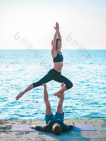 年轻的美丽的夫妇练习爱人瑜伽海海滩水男人。女人日常<strong>实践户外</strong>自然背景健康的生活方式概念