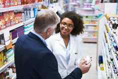 选择药店信任有帮助的年轻的女药剂师帮助客户选择药物治疗药店
