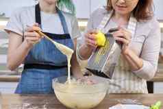 特写镜头女人摩擦柠檬热情刨丝器女准备面团松饼