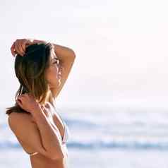 美丽的一天海滩美丽的年轻的女人摆姿势比基尼前海滩