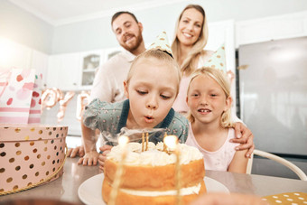 孩子们生日聚会，派对蛋糕蜡烛吹妈妈。父亲妹妹首页厨房有趣的兴奋快乐孩子们庆祝享受有趣的父母特殊的事件