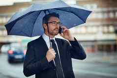 准备业务世界风暴成熟的商人会说话的手机持有伞城市