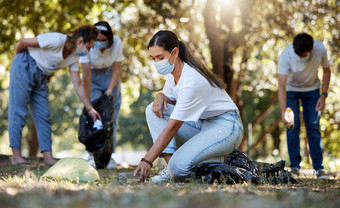 集团志愿者挑选清洁减少污染公共自然公园多样化的社区穿脸面具保护疾病收集污垢清理