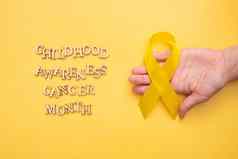 童年癌症意识月文本木信女手黄色的丝带黄色的背景