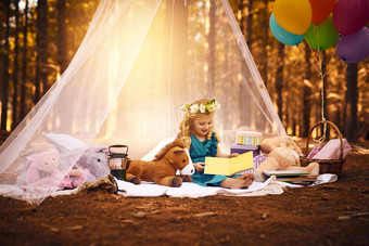 故事快乐女孩阅读故事书坐着毯子森林
