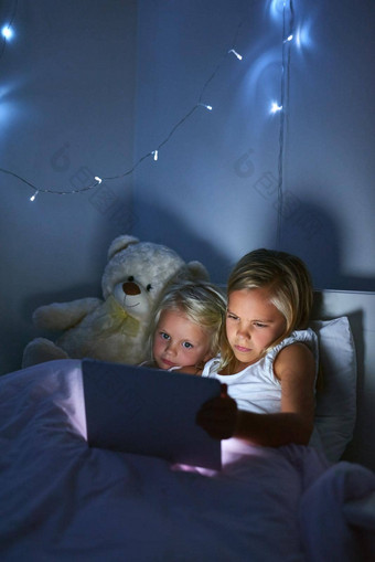 学习日益增长的数字年龄女孩数字平板电脑睡觉前