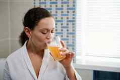 美丽的女人喝水冒泡的抗氧化剂矿物质维生素营养补充特写镜头