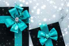 冬天假期礼物翡翠丝绸弓发光的雪冻大理石背景圣诞节礼物惊喜