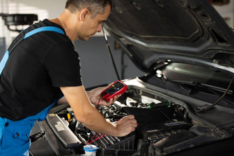 专业机械师工作车服务好电工电电池带电完全检查电池电压电万用表车起动器电池