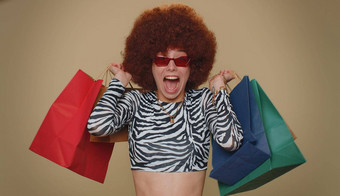 快乐微笑年轻的女人显示购物袋广告折扣惊讶低价格
