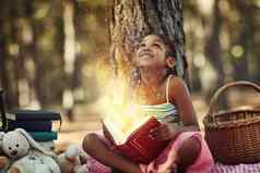书开放明亮的世界女孩阅读书发光的页面森林