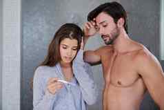 年轻的夫妇担心采取怀孕测试首页