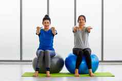 成人年轻的女人运动服装有氧运动瑜伽锻炼坐着健身球