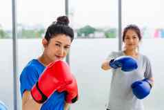 成人年轻的女人微笑体育健身拳击手穿手套练习踢拳击