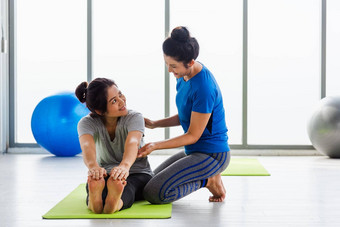 女人老师教成人学生瑜伽伸展运动位置工作室