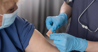 高级女人接收疫苗医疗工人接种疫苗上了年纪的病人流感流感肺炎冠状病毒