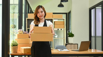 年轻的女人企业家工作<strong>首页</strong>办公室准备包裹盒子<strong>产品</strong>交付在线销售电子商务概念