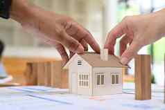 裁剪成像年轻的夫妇持有房子模型真正的房地产投资购买出售