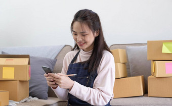 快乐年轻的亚洲女人企业家微笑销售成功检查订<strong>单</strong>在线购物商店智能<strong>手机首页</strong>办公室概念商人业务在线电子商务