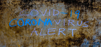 有创意的拍摄科维德冠状病毒警报写粗糙的墙粉笔水平拍摄