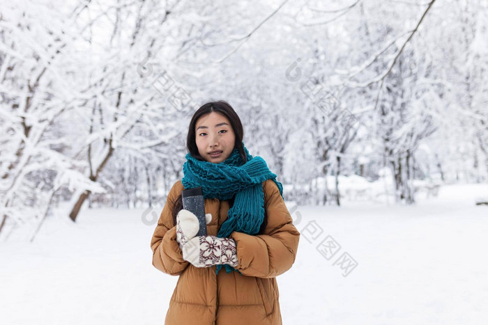 肖像年轻的美丽的亚洲学生少年冬天雪公园温暖的衣服女人走持有杯热喝