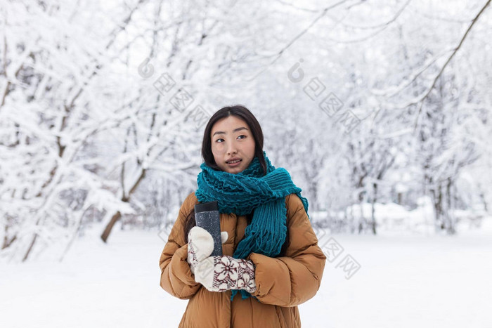 肖像年轻的美丽的亚洲学生少年冬天雪公园温暖的衣服女人走持有杯热喝