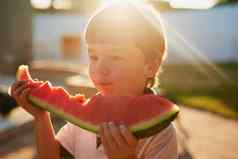 甜蜜的口味夏天可爱的男孩吃片西瓜后院
