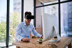 采取工作虚拟世界快乐年轻的商人穿虚拟现实耳机工作桌子上办公室