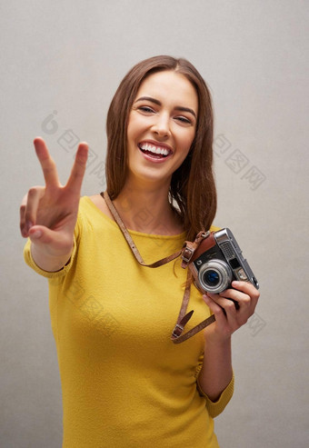 和平摄影师工作室肖像有吸引力的年轻的女摄影师摆姿势相机灰色背景