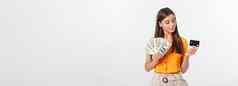 照片快乐年轻的女人站孤立的灰色背景持有钱信贷卡