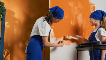 妈妈。孩子重新装修公寓橙色油漆颜色