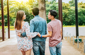 不忠的女孩走公园的男朋友持有男人。手爱三角形概念女人持有手男人。走的男朋友户外