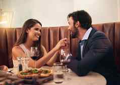 发现快乐年轻的夫妇享受浪漫的晚餐日期餐厅