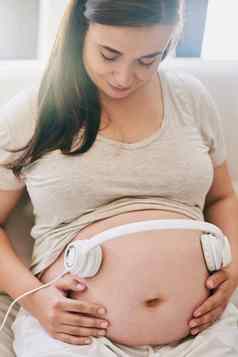 音乐连接女人穿耳机怀孕了肚子