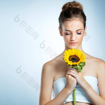 失去了柔软工作室拍摄美丽的年轻的女人闻向日葵