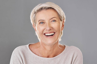 梳理护肤品脸快乐成熟的女人笑工作室灰色背景高级女感觉新鲜的享受免费的时间护理卫生治疗快乐例程宠爱