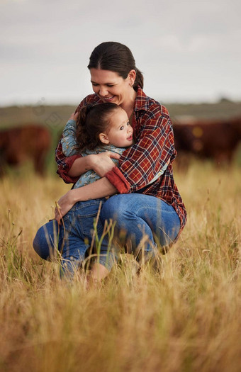 爱家庭护理妈妈。女儿拥抱场农场牛农民女孩农业农业乳制品行业草地牧场在户外