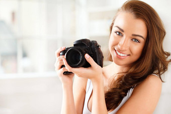 摄影师数字相机摄影女人采取照片图片内部肖像年轻的女微笑持有照片齿轮美拍摄快乐模型