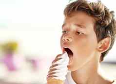 尖叫冰奶油快乐的男孩吃大冰淇淋海滩