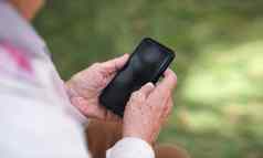女人手智能手机发短信发送消息移动电话在户外
