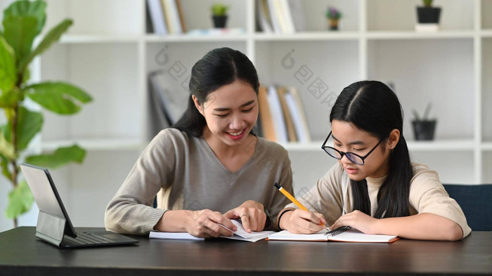 快乐亚洲妈妈。帮助女儿家庭作业