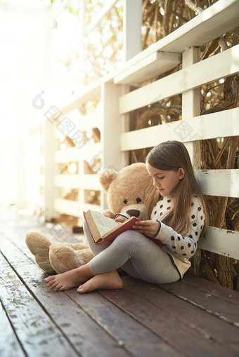 他们全神贯注好故事女孩阅读书泰迪熊