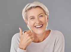 护肤品健康拇指快乐成熟的女人微笑显示赢得手手势工作室背景高级支持推荐化妆品手术治疗产品皱纹