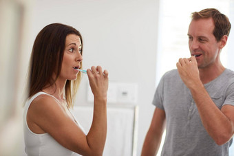 采取口服健康手成熟的夫妇刷牙牙齿浴室