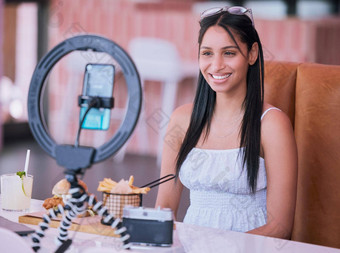 社会媒体影响者在线视频食物咖啡馆智能手机技术移动光生活方式视频博客快乐年轻的女孩餐厅电影相机女人吃薯条汉堡鸡尾酒
