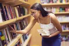 图书馆书女人阅读打印书大学大学教育学习知识年轻的基因奖学金学生架子上研究英语项目考试测试