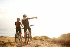 骑自行车自由年轻的夫妇欣赏视图山顶自行车骑